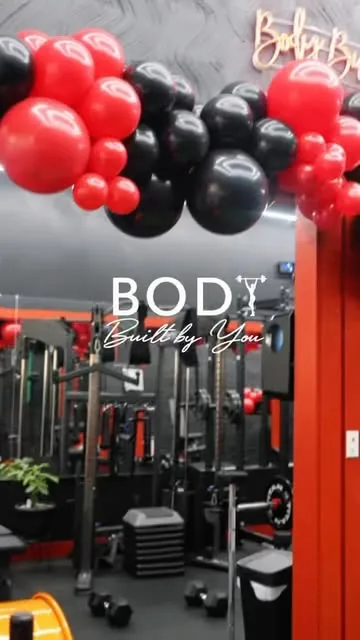 Instagram reel: the Body Built by You logo wall with red and black balloons
